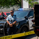 MINNEAPOLIS, MN - JUNE 16: A woman holds up her phone as Minneapolis Police officers respond at a crime scene on June 16, 2020 in Minneapolis, Minnesota. The Minneapolis Police Department has been under increased scrutiny by residents and elected officials after the death of George Floyd in police custody on May 25.